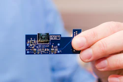 A MEMS-based atomic force microscope developed by engineers at the University of Texas at Dallas is about 1 square centimeter in size (top center). Here it is attached to a small printed circuit board that contains circuitry, sensors and other miniaturized components that control the movement and other aspects of the device.