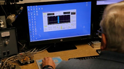 In this Feb. 21, 2017 photo, lifelong ham radio operator and expert tinkerer Tom Thompson, looks at a representation of radio waves on his computer, inside his basement home office, where he operates a ham radio and other devices, in Boulder, Colo. After discovering that radio interference was being caused by high-powered lights from home marijuana growers, Thompson built an electronic filter and has given them to nearby growers.