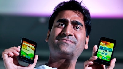 In this July 7, 2016 file photo, Mohit Goel, Director of Indian company Ringing Bells Pvt. Ltd. shows Freedom 251 smartphones at a press conference in New Delhi, India. Police say Mohit Goel was arrested late Thursday in the northern town of Ghaziabad following a complaint that his company, Ringing Bells, had not supplied the handsets that a phone distribution company had paid for.
