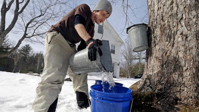 Parker's Maple Barn employee Kyle Gay pours maple tree sap into a larger bucket, Tuesday, Feb. 21, 2017, in Brookline, N.H. Sen. Maggie Hassan, D-NH, led a discussion with maple syrup producers in New Hampshire about how climate change is impacting their industry.