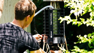 In this photo provided by Microsoft, Microsoft researcher Ethan Jackson sets up a trap for mosquitoes in Harris County, Texas in 2016. A new high-tech version trap is promising to catch the bloodsuckers while letting friendlier insects escape, and even record the exact weather conditions when different species emerge to bite.