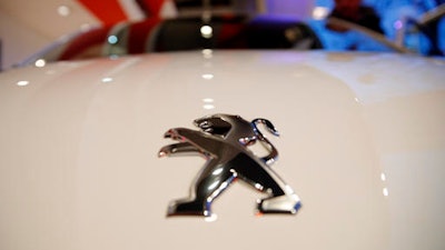 The logo of French carmaker Peugeot is pictured during the presentation of the company's 2016 full year results, in Paris, Wednesday, Feb.22, 2017. French carmaker PSA Group saw its profits jump last year and is giving dividends for the first time since 2011, burnishing its image as it weighs a buyout of General Motors' money-losing European operations.