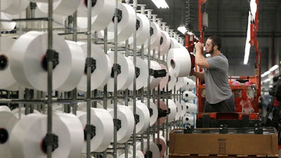 In this Friday, Oct. 21, 2016, file photo, a worker loads spools of thread at the Repreve Bottle Processing Center, part of the Unifi textile company, in Yadkinville, N.C. The Institute for Supply Management, a trade group of purchasing managers, issues its index of manufacturing activity for January, on Wednesday, Feb. 1, 2017.