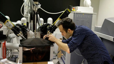 Iranian-born bioengineer researcher Nima Enayati works on a robotic surgery machine during an interview with the Associated Press at the Polytechnic University of Milan, Italy, Tuesday, Jan. 31, 2017. An Iranian researcher at Milan's Polytechnic University, Enayati was refused check-in Monday at Milan's Malpensa Airport for his U.S.-bound flight on Turkish Airlines after the Trump administration's executive order came down.