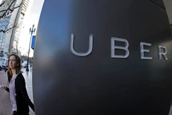 In this file photo taken Tuesday, Dec. 16, 2014, a woman walks past the company logo of the internet car service, Uber, in San Francisco, USA. Uber’s chief executive ordered an urgent investigation Monday Feb. 20, 2017, into a sexual harassment claim made by a female engineer who alleged her prospects at the company evaporated after she complained about advances from her boss.