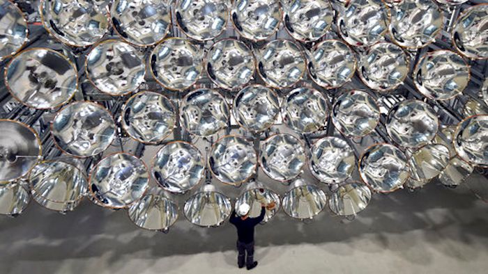In this March 21, 2017 photo engineer Volkmar Dohmen stands in front of xenon short-arc lamps in the DLR German national aeronautics and space research center in Juelich, western Germany. The lights are part of an artificial sun that will be used for research purposes.