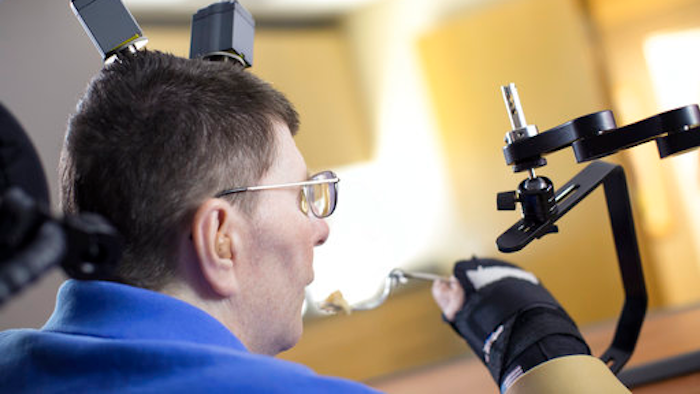 In this undated photo made available on Tuesday, March 28, 2017 by Case Western Reserve University, Bill Kochevar feeds himself, in Cleveland, Ohio. A paralyzed man was able to feed himself for the first time in eight years, after doctors implanted electronic sensors into his brain and arm that restored the broken connection between them. Kochevar, 56, was paralyzed from the shoulders down after a cycling accident in Cleveland nearly a decade ago.