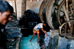 In this Monday, Feb. 6, 2017 photo, a Bangladeshi boy processes animal hide inside a factory at the highly polluted Hazaribagh tannery area in Dhaka, Bangladesh. Hazardous, heavily polluting tanneries with workers as young as 14 supplied leather to companies that make shoes and handbags for Western brands, a nonprofit group that investigates supply chains says.