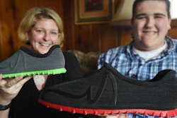 In a Wednesday, March 1, 2017 photo, Broc Brown, right, shows off his new shoes with Feetz CEO Lucy Beard at his grandmother's home in Michigan Center, Mich. Brown, who has Sotos Syndrome and is 7 feet, 8 inches tall, was given a new pair of about size 28 shoes from Feetz. Feetz is a company that uses an app to convert photos of someone’s feet into a 3-D model, which can be measured to create custom-fit shoes manufactured by a 3-D printer.