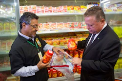 Brazil's Agriculture Minister Blairo Maggi, right, accompanied by a sanitary inspection agent, collect meat products for testing, in a supermarket in Brasilia, Brazil, Wednesday, March 22, 2017. South Africa is partially suspending imports of Brazilian meat, the latest country to do so in the wake of an inspection scandal. Brazilian investigators charge that health inspectors in the South American country were bribed to overlook the sale of expired meats and chemicals and other products were added to meat to improve its appearance and smell.
