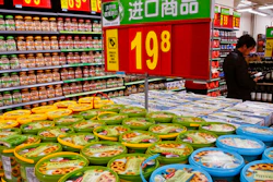 In this Tuesday, March 14, 2017 photo, a man looks at imported wines on display for sale near the imported cookies and nuts, at Walmart in Beijing. China's trading partners are bringing the top U.N. food standards official to Beijing in a last-ditch attempt to persuade regulators to scale back plans for intensive inspections of food imports - including such low-risk items as wine and chocolate - that Washington and Europe say could disrupt billions of dollars in trade.