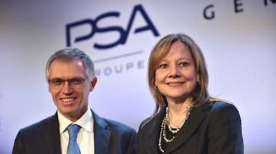 Carlos Tavares, CEO of PSA, left, and GM CEO Mary Barra pose for photographers before addressing the media in Paris, France, Monday, March 6, 2017. General Motors is selling its loss-making European car business, including Germany's Opel and British brand Vauxhall, to France's PSA group in a deal that realigns the industry in the region.