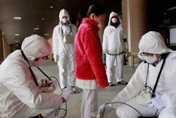 In this March 24, 2011 file photo, a young evacuee is screened at a shelter for leaked radiation from the tsunami-ravaged Fukushima Dai-ichi nuclear power plant in Fukushima, northeast of Tokyo. Doctors say over 180 thyroid cancer cases among Fukushima youngsters found since the nuclear accident cannot be linked to radiation, which they say is not the region’s biggest cause of health problems.