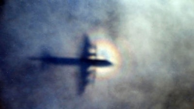 FILE - In this March 31, 2014 file photo, the shadow of a Royal New Zealand Air Force P3 Orion is seen on low level cloud while the aircraft searches for missing Malaysia Airlines Flight MH370 in the southern Indian Ocean, near the coast of Western Australia. A series of catastrophic electrical and other failures may have led to the crash of Flight 370 over the Indian Ocean, according to a lawsuit filed Friday, March 3, 2017, in the U.S. on behalf of the families of 44 people on board the still missing plane.