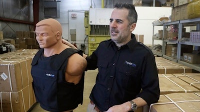 In this Monday, Feb. 27, 2017, photo, Tom Nardone, owner of PriveCo, which sells bulletproof vests, poses in his warehouse in Troy, Mich., with a mannequin wearing a test vest. In more than a hundred videos he's posted on YouTube, Nardone takes aim at racks of ribs, laptop computers and tires to illustrate what a bulletproof vest can do. While he advertised in magazines and went to gun shows, he realized that to reach a wider audience he needed to be online. And he didn't want a demonstration of just the vests.