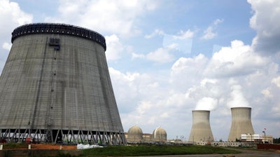 In this Friday, June 13, 2014, file photo, a new cooling tower for a nuclear power plant reactor that's under construction stands near the two operating reactors at Plant Vogtle power plant in Waynesboro, Ga. Westinghouse Electric Co., the U.S. nuclear unit of Japan’s Toshiba Corp., filed for bankruptcy protection Wednesday, March 29, 2017, calling into question the future of a number of billion-dollar nuclear projects under construction, including two in the U.S.