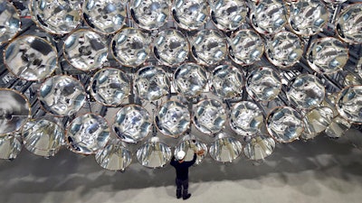 In this March 21, 2017 photo engineer Volkmar Dohmen stands in front of xenon short-arc lamps in the DLR German national aeronautics and space research center in Juelich, western Germany. The lights are part of an artificial sun that will be used for research purposes.