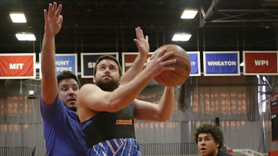 Jeremias Engelmann takes the ball to the hoop while wearing a Catapult monitoring system compression vest in a basketball game Friday, March 3, 2017, in Cambridge, Mass. Athlete trackers are being used by hundreds of teams in dozens of sports helping coaches plan their practices, make substitutions in games and decide when a player is ready to return from an injury by accumulating biometric and positioning data collected from the trackers.