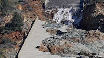 Officials inspect Oroville Dam's crippled spillway Tuesday, Feb. 28, 2017, in Oroville, Calif. California water authorities stopped the flow of water down the spillway, Monday, allowing workers to begin clearing out massive debris that's blocking a hydroelectric plant from operating.