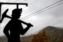 In this Oct. 16, 2014 file photo, fog hovers over a mountaintop as a cutout depicting a coal miner stands at a memorial to local miners killed on the job in Cumberland, Ky.
