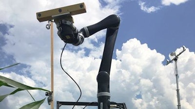 To develop 3-D images of corn plants in the field, DeSouza's team developed a combination approach of a mobile sensor tower (in background) and an autonomous robot vehicle equipped with three levels of sensors and an additional robotic arm.