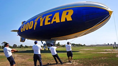 This Sept. 23, 2015 photo shows ground crew moring the Goodyear Blimp 'Spirit of Innovation' as it comes in for a landing at Goodyear Airship Base in Carson, Calif. Goodyear is letting the helium out of the last of its fabled fleet of blimps on Tuesday, March 14, 2017. Its replacement, 'Wingfoot Two,' will look about the same when it arrives at Goodyear’s California airship base in Carson later this year. But it will be a semi-rigid dirigible.