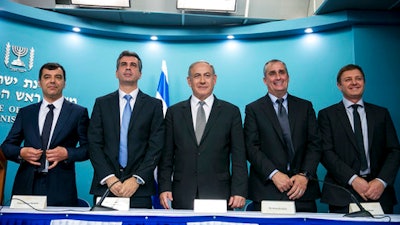 In this Tuesday, 14 March 2017 photo, from left: co-founder and CTO of Mobileye Prof. Amnon Shashua, Israeli Economy Minister Eli Cohen, Israeli Prime Minister Benjamin Netanyahu, Intel CEO Brian Krzanich and the co-founder and CTO of Mobileye, Ziv Aviram, attend a press conference at the Prime Minister's Office in Jerusalem.