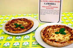 Pizzas are displayed near a sign listing the police operations against restaurants and bars owned by the Camorra crime syndicate, during a report on organized crime infiltration in Italy's much prized food and agriculture businesses at the Coldiretti, the Italian farmers association headquarters in Rome, Tuesday, March 14, 2017. Organized crime has a seemingly insatiable appetite for farm and food businesses, one of the few economic sectors experiencing growth during Italy's protracted economic crisis.