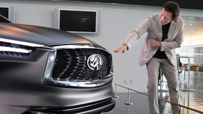 In this Feb. 27, 2017 photo, Nissan's design chief Alfonso Albaisa speaks with an Infiniti Prototype during an interview at the Nissan Technical Center in Atsugi, near Tokyo. Albaisa draws upon the cultures of Japan, America and Cuba in concocting car designs with a flair that once was lacking at Japanese automakers, critics say, but is becoming evident as they globalize.