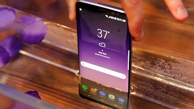 In this Friday, March 24, 2017, photo, a Samsung Galaxy S8 mobile phone is shown partially submerged to demonstrate its water resistance, in New York. The Galaxy S8 features a larger display than its predecessor, the Galaxy S7, and sports a voice assistant intended to rival Siri and Google Assistant.