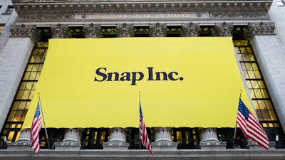 A banner for Snap Inc. hangs from the front of the New York Stock Exchange, Thursday, March 2, 2017, in New York. The company behind the popular messaging app Snapchat is expected to start trading Thursday after a better-than-expected stock offering.