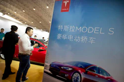 In this April 25, 2016, file photo, visitors look at a Tesla Model S electric car on display at the Beijing International Automotive Exhibition in Beijing. Tesla said August 15, 2016, that the removal of the term autopilot from its website for China was a mistake and the term is being restored.