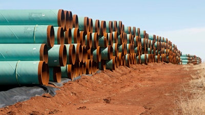 In this Feb. 1, 2012 file photo, miles of pipe ready to become part of the Keystone Pipeline are stacked in a field near Ripley, Okla. It was a nice story while it lasted. Moments from signing orders to advance the stalled Keystone XL and Dakota Access pipelines, President Donald Trump comes up with the idea of making the projects use pipes and steel made in the U.S. He inserts a “little clause” to that effect and vows the projects will only happen if his buy-American mandate is met.