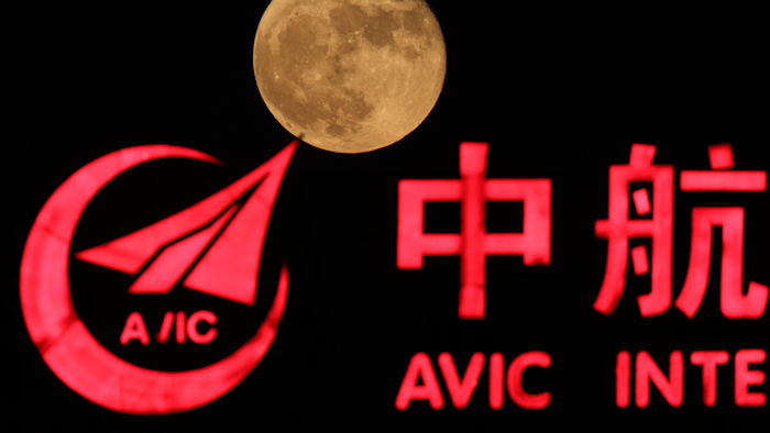 In this Tuesday, Nov. 15, 2016, file photo, the moon rises over a logo for AVIC or Aviation Industry Corp in Beijing, China. China is talking with the European Space Agency about collaborating on a human outpost on the moon.