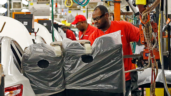 In this April 6, 2016, photograph, a technician uses a lift to move a back seat section into a new Altima on the assembly line at the Nissan Canton Vehicle Assembly Plant in Canton, Miss. U.S. industrial production posted a solid gain in March 2017, reflecting a record rebound in utility output. But a closely watched gauge of manufacturing posted its first setback in seven months as auto production dropped sharply.