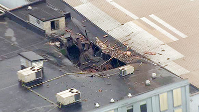 This Monday, April 3, 2017 photo from video by KMOV shows damage to the roof of a box company in St. Louis after a boiler exploded and flew before crashing through the roof of a nearby laundry business. Authorities said several people were killed as a result of the explosion.