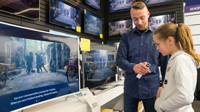 In this photo taken Saturday, April 15, 2017, Salome Sigurjonsdottir, 10, tests a voice-controlled television in an electronics store in Reykjavik. Sales assistant Einar Dadi said none of his TVs understood Icelandic. The revered Icelandic language, seen by many as a source of identity and pride, is being undermined by the widespread use of English both for mass tourism and in the voice-controlled artificial intelligence devices coming into vogue.