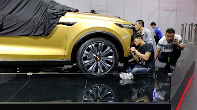 Workers prepare for the Auto Shanghai 2017 show at the National Exhibition and Convention Center in Shanghai, China, Tuesday, April 18, 2017. At the auto show, the global industry's biggest marketing event of the year, almost every global and Chinese auto brand is showing at least one electric concept vehicle, if not a market-ready model.