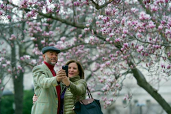In this Tuesday, Feb. 28, 2017, file photo, Fidelio Desbradel and his wife, Leonor Desbradel, of the Dominican Republic, take a selfie in front of a Tulip Magnolia tree in Washington. A selfie reveals more than whether it’s a good hair day. A company has developed facial analytics technology to help estimate life expectancy by analyzing your face from a photo you upload online. Life insurance companies are interested in the product because it may help them reduce your wait for coverage and boost their sales.