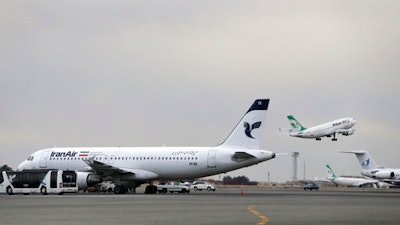 In this Feb. 7, 2016, file photo, an Iranian Mahan Air passenger plane takes off as a plane of Iran's national air carrier Iran Air, left, is parked at Mehrabad airport in Tehran, Iran. European airplane manufacturer ATR said it signed a deal with Iran Air for 20 aircraft with option for 20 more on Thursday, April 13, 2017.