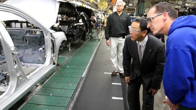 In this Thursday, Feb. 25, 2010, file photo, production team member Steve Turley, right, and Toyota President Akio Toyoda look into a Camry on the assembly line at the Toyota Motor Manufacturing plant in Georgetown, Ky. Toyota said Monday, April 10, 2017, it is investing $1.3 billion to retool its sprawling Georgetown factory, where the company's flagship Camry sedans are built. No new factory jobs are being added, but Toyota says the upgrades amount to the biggest single investment ever at one of its existing plants in the United States.