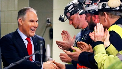 FILE - In this April 13, 2017 file photo Environmental Protection Agency (EPA) Administrator Scott Pruitt, left, shakes hands with coal miners during a visit to Consol Pennsylvania Coal Company's Harvey Mine in Sycamore, Pa. The Trump administration wants to trash Obama-era rules to limit water pollution from coal-fired power plants. Pruitt announced the change this week. Administrator Scott Pruitt sent a letter to a coalition of energy companies that lobbied against the 2015 water pollution rule.