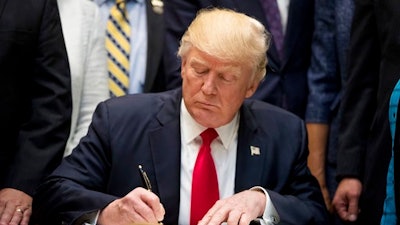 President Donald Trump signs the Education Federalism Executive Order during a federalism event with governors in the Roosevelt Room of the White House in Washington, Wednesday, April 26, 2017.