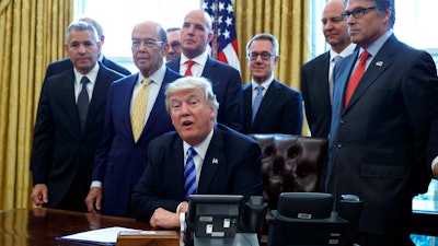 In this file photo, President Donald Trump announces the approval of a permit to build the Keystone XL pipeline. Amid staff turmoil and shake-ups, President Trump is plucking away at another piece of his agenda: undoing Obama.