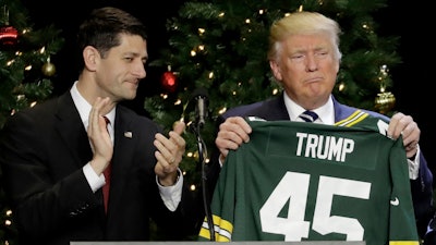 In this Dec. 13, 2016, file photo, President-elect Donald Trump holds up Green Bay Packers jersey given to him by House Speaker Paul Ryan at a rally in West Allis, Wis. President Donald Trump heads to Ryan's congressional district in Wisconsin on Tuesday, April 18, 2017, facing low approval ratings and in the wake of his failure to fulfill a campaign promise to repeal and replace the federal health care law.