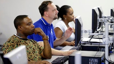 In this Friday, March 10, 2017, file photo, job seekers look at their respective computer screens during a resume writing class at the Texas Workforce Solutions office in Dallas. On Thursday, April 13, 2017, the Labor Department reported that fewer Americans sought unemployment benefits the week before, which is evidence of a stable job market and greater security for workers.