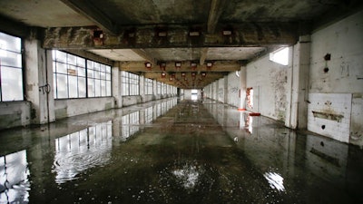 In this photo taken on Friday, Feb. 3, 2017, water comes from the roof inside the abandoned Alfa Romeo car factory, in Arese, near Milan, Italy, Friday, Feb. 3, 2017. Lombardy is Italy's most productive region with an annual GDP of 337 billion euros, making it Europe's second most productive region. And yet the landscape is dotted with ghosts of industries past.