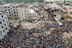 In this April 25, 2013, file photo, Bangladeshi people gather as rescuers look for survivors and victims at the site of a building that collapsed a day earlier, in Savar, near Dhaka, Bangladesh. An international rights group says dozens of global clothing companies are not complying with a plan to ensure better safety in Bangladesh garment factories following the deadly collapse of a building four years ago.
