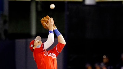 In this March 15, 2017, file photo, Philadelphia Phillies second baseman Chris Coghlan catches a pop fly in the fifth inning of a spring training baseball game in Tampa, Fla. Coghlan spent spring training with the Phillies using a wrist band to measure his sleep and recovery.