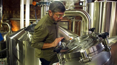 In this Feb. 24, 2017, image from video, Brooklyn Brewery co-founder Steve Hindy inspects brewing equipment inside the brewery, in New York. Brooklyn Brewery is now one of the country’s biggest craft breweries, but Hindy remembers when he had to convince a small Brooklyn club to carry his beer.